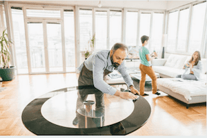 Image of a Man Cleaning a Round Shaped Glass Table Top